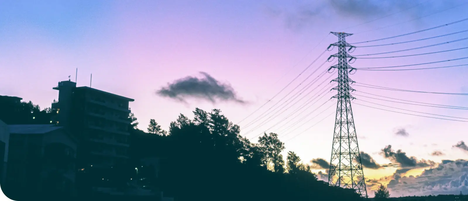 夕暮れ時の送電鉄塔と建物の風景